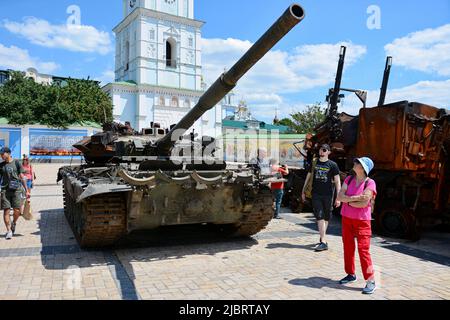 Kiew, Ukraine. 07.. Juni 2022. Passanten sehen sich den zerstörten russischen Panzer T-72 an, der im Zentrum von Kiew ausgestellt ist. In der ukrainischen Hauptstadt wird eine Ausstellung verbrannter russischer Panzer und anderer gepanzerter Fahrzeuge fortgesetzt, um die Aufmerksamkeit auf den Krieg in anderen Teilen des Landes zu lenken. Kredit: SOPA Images Limited/Alamy Live Nachrichten Stockfoto