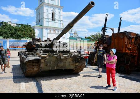 Kiew, Ukraine. 07.. Juni 2022. Passanten sehen sich den zerstörten russischen Panzer T-72 an, der im Zentrum von Kiew ausgestellt ist. In der ukrainischen Hauptstadt wird eine Ausstellung verbrannter russischer Panzer und anderer gepanzerter Fahrzeuge fortgesetzt, um die Aufmerksamkeit auf den Krieg in anderen Teilen des Landes zu lenken. (Foto: Aleksandr Gusev/SOPA Images/Sipa USA) Quelle: SIPA USA/Alamy Live News Stockfoto