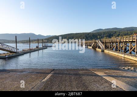 Rocky Point Park während der Sonnenuntergangszeit. Langer Pier über dem Meer. Port Moody, British Columbia, Kanada. Stockfoto