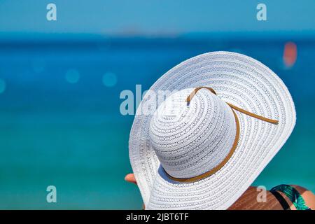 Frankreich, Côtes d'Armor, Côte de Granit Rose, Perros Guirec, junge Frau mit Hinterhut und Blick auf das blaue Meer, Urlaubsinspiration Stockfoto