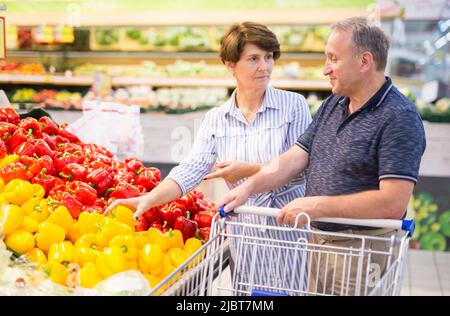 Reifes Paar Ehemann und Ehefrau wählen Paprika im Supermarkt Stockfoto