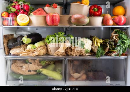 Geöffneter Kühlschrank mit vegetarisch gesundem frischem Obst, Gemüse, reich an Antioxidantien, lebendige Lebensmittel im Kühlschrank. Gesunde Ernährung. Entgiftung. Stockfoto