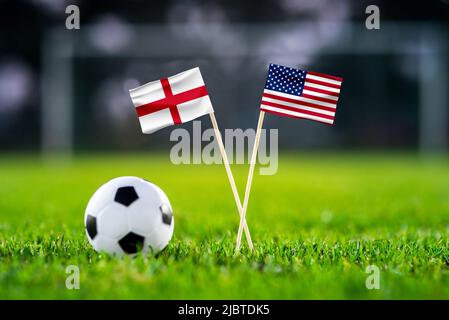 England gegen die Vereinigten Staaten von Amerika, Nationalflaggen auf grünem Gras mit Fußballball. USA und England, Gruppe-B-Fußballspiel in Katar Stockfoto