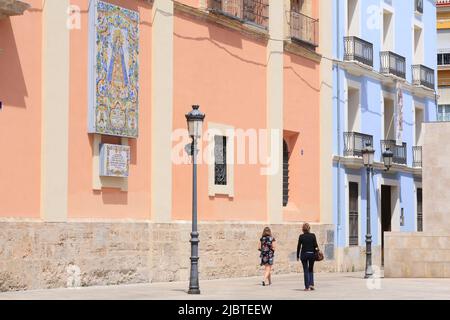 Spanien, Valencia, Plaza Décimo Junio Bruto, Passanten entlang der Fassade des Real Basílica De Nuestra Senora De Los Desamparados, Azulejos, die unsere Liebe Frau von den Verlassenen Stockfoto