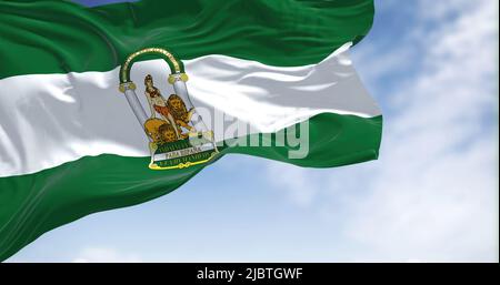 Andalusische Flagge winkt an einem klaren Tag im Wind. Andalusien ist die südlichste autonome Gemeinschaft auf der Halbinsel Spanien, die bevölkerungsreichste und die s Stockfoto