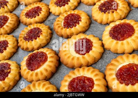 Hintergrund von Cookies mit einem Jam Center. Köstliches Gebäck zum Tee. Süßwarenprodukt. Kekse zu Hause backen. Selektiver Fokus. Stockfoto