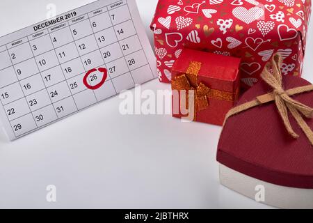 Der 26. dezember ist im Kalender markiert. Zeit, Weihnachtsgeschenke zu öffnen. Konzept für den Boxtag. Rote Geschenke und Kopierbereich. Stockfoto