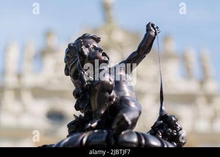 Linderhof, Deutschland - 21. Aug 2022: Skulptur eines Engels. Im verschwommenen Hintergrund: Schloss Linderhof. Stockfoto