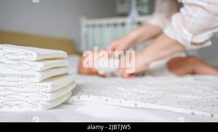 Frau legt sorgfältig Pullover auf kleine Tochter Baby Stockfoto