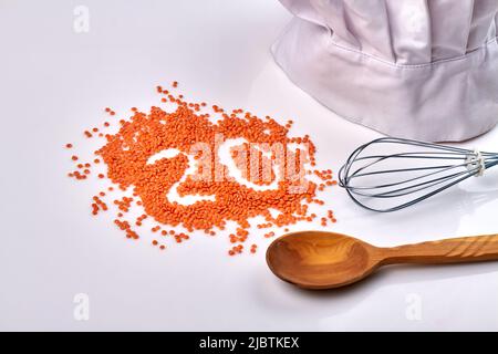 Draufsicht Stapel Linsenbohnen mit Löffel und Mischwerkzeug auf weißem Hintergrund. Stockfoto