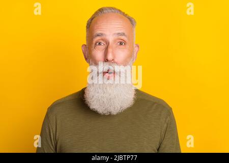 Foto von beeindruckt gealterten grauen Bart Mann tragen grünen Pullover auf gelbem Hintergrund isoliert Stockfoto