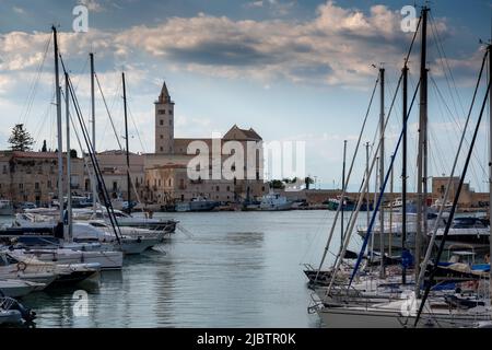 Trani, Apulien, Italien. August 2021. Schöner Blick auf die Basilika der Kathedrale durch die Schiffe, die in der Marina festgemacht sind. Stockfoto