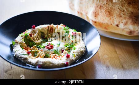Köstlicher hausgemachter libanesischer Hummus mit frischen Granatapfelkernen Stockfoto