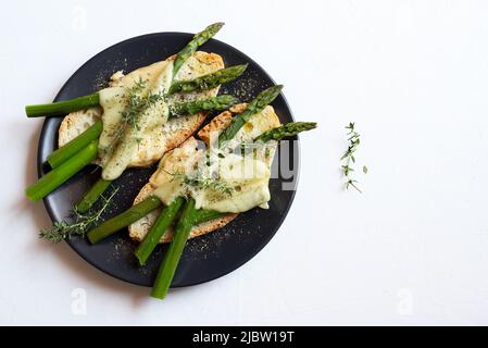 Spargel und Käse Bruschetta auf einem Teller isoliert auf weißem Hintergrund. Direkt darüber. Gesunde Ernährung. Stockfoto