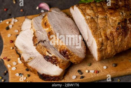 Stücke von gebackenem Schweinefleisch und Gewürzen, Nahaufnahme. Stockfoto