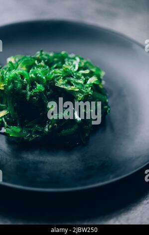 Algensalat auf schwarzem Teller Stockfoto