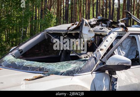 Schussauto während des Krieges in der Ukraine. Ein Auto von Zivilisten mit Schrapnelllöchern von Explosionen. Autounfall. Autofriedhof. Spuren von Schüssen auf den Körper. Stockfoto