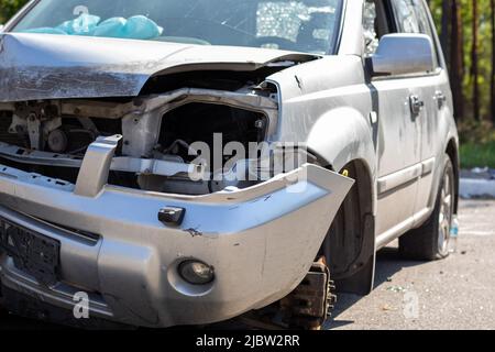 Defekte Scheinwerfer infolge einer Kollision. Gebrochenes graues Auto nach einem Unfall. Konzept eines Autounfalls. Notscheinwerfer, Motorhaube und Stoßfänger beschädigt. D Stockfoto