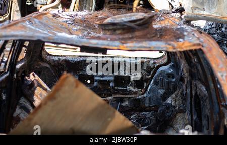 Defekte und verbrannte Autos auf dem Parkplatz, Unfall oder vorsätzlicher Vandalismus. Verbranntes Auto. Folgen eines Autounfalls. Durch Brandstiftung beschädigt. Kippe von Civi Stockfoto