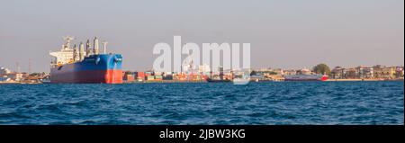 Stone Town, Sansibar - Jan, 2021: Panoramablick auf den Hafen von Sansibar mit großen Schiffen, Kränen und Ladungen in der Nähe des Kais. Afrika. Stockfoto