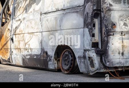 Autos nach dem Feuer. Eiserne Teile eines verbrannten Autos. Ausgebrannte Autos, die auf der Seite einer ruhigen Landschaft stehen. Explosion, die Folge eines Feuers. Auto insu Stockfoto