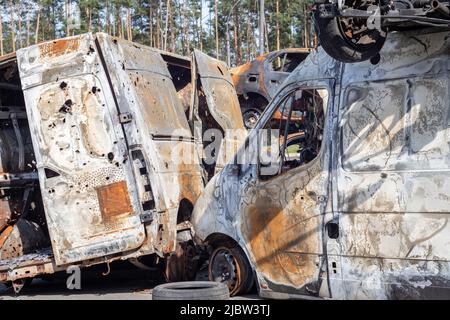 Autos nach dem Feuer. Eiserne Teile eines verbrannten Autos. Ausgebrannte Autos, die auf der Seite einer ruhigen Landschaft stehen. Explosion, die Folge eines Feuers. Auto insu Stockfoto