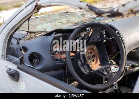 Nahaufnahme des Lenkrads eines Autos nach dem Unfall. Kein Fahrer-Airbag. Das Lenkrad eines Autos, nachdem es aus der Nähe eines Airbags geschossen wurde. Br Stockfoto