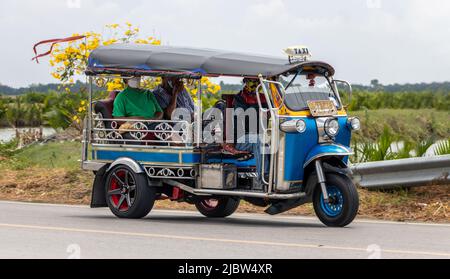 Ein traditionelles Motor-Dreirad - Tuk Tuk fährt auf einer ländlichen Straße, Thailand Stockfoto