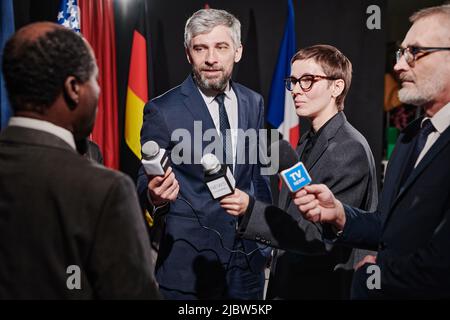 Eine Gruppe von Journalisten, die Mikrofone in der Hand des Sprechers halten und ein Interview führen Stockfoto