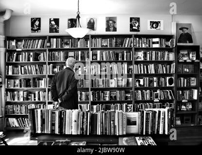 Ein Kunde durchliest die große Auswahl an Büchern, die im berühmten City Lights Booksellers Shop in San Francisco, Kalifornien, zum Verkauf stehen. Stockfoto