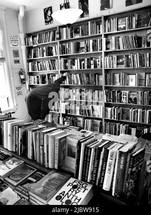 Ein Kunde durchliest die große Auswahl an Büchern, die im berühmten City Lights Booksellers Shop in San Francisco, Kalifornien, zum Verkauf stehen. Stockfoto