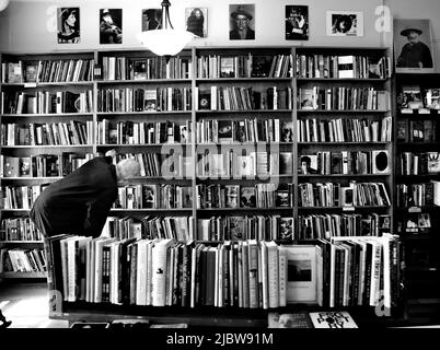 Ein Kunde durchliest die große Auswahl an Büchern, die im berühmten City Lights Booksellers Shop in San Francisco, Kalifornien, zum Verkauf stehen. Stockfoto