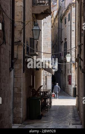 Älterer Mann mit Stock zu Fuß in der engen Straße in der Altstadt, Dubrovnik, Kroatien Stockfoto