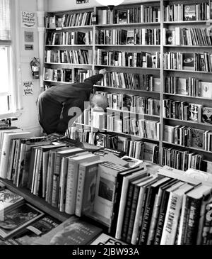 Ein Kunde durchliest die große Auswahl an Büchern, die im berühmten City Lights Booksellers Shop in San Francisco, Kalifornien, zum Verkauf stehen. Stockfoto