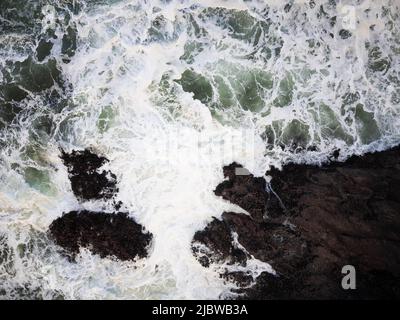 Sturm auf dem Meer. Tobende Wellen stürzen gegen das steinerne Ufer. Die Kraft und Majestät der Natur. Wunderschöne Meereslandschaft. Ökologie, Geologie, Wetter, Elemente Stockfoto