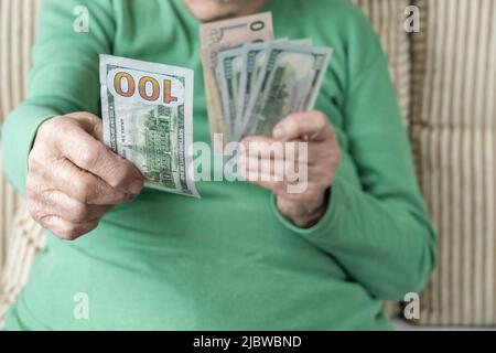 Closeup faltige Hand einer älteren Frau mit amerikanischen Dollar Stockfoto