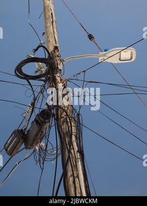 Kabelgewirr an einem Versorgungsmast in Bermuda. Eine Szene, die auf der ganzen Welt dupliziert wurde. Mangelnde Wartung. Stockfoto