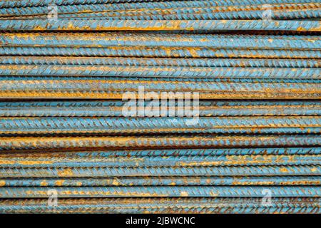 Metallbeschläge für Stahlbeton. Hauptbaumaterialien. Hintergrund und rostige Eisenverstärkungsstäbe. Rot-orange Farbe von Eisenoxid auf r Stockfoto