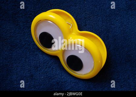 Gelbe Augen blicken auf blaues Tuch Stockfoto