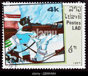 Abgesagte Briefmarke gedruckt von Laos, die Biathlon zeigt, die die Olympischen Winterspiele in Calgary fördert, um 1988. Stockfoto