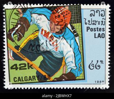 Abgesagte Briefmarke gedruckt von Laos, die Hockey zeigt, die die Olympischen Winterspiele in Calgary fördert, um 1988. Stockfoto