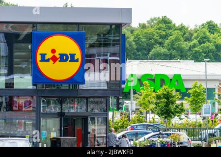 LIDL-Schaufenster, Schaufenster oder Fassade mit ASDA-Schild dahinter im Hintergrund. Preisgünstiger Supermarkt, Wettbewerb, steigende Lebenshaltungskosten, „große drei“. VEREINIGTES KÖNIGREICH Stockfoto