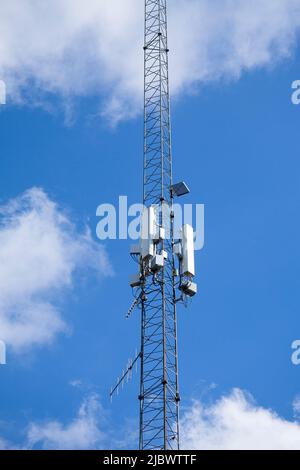 Zellenturm, Telekommunikationsmast gegen blauen Himmel und weißen Wolken Hintergrund. Stockfoto