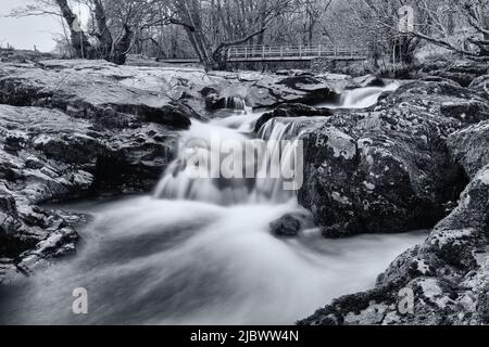 Schwarz-Weiß-Langzeitaufnahme der High Cascades Bridge in Ullswater den Fluss hoch von Aira Force Stockfoto