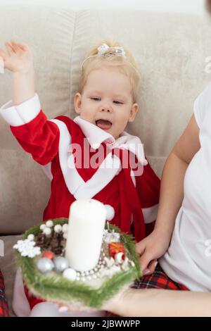 Kindermädchen in weihnachtskleid mit Cochlea-Implantaten gekleidet Spaß zu Hause - Vielfalt und Hörgeräte und innovative Technologien für die Behandlung Stockfoto