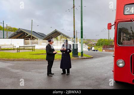 Dudley, West Midlands-vereinigtes Königreich Mai 01 2022 zwei Männer sprechen einer ein Busfahrer ein anderer ein Polizist in der Kleidung der 40er Jahre neben einem roten Doppeldecker Stockfoto