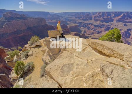 Ein Mann, der von einer Klippe am Moran Point Arizona auf den Südrand des Grand Canyon blickt. Stockfoto
