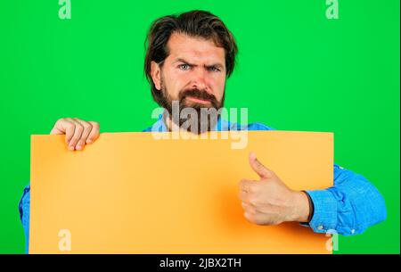 Bärtiger Mann mit leerem Werbebanner, der den Daumen nach oben zeigt. Leere Tafel mit Platz für Text. Stockfoto