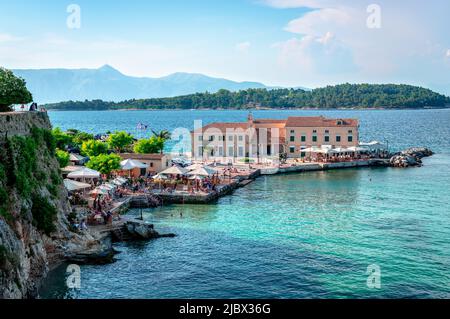 Korfu, Griechenland - 4 2022. Juni: Schwimmer genießen die Nachmittagssonne und das kristallklare Wasser des Faliraki-Strandes. Stockfoto