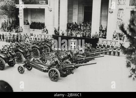 Hitler bei der Parade in Rom von 30.000 -- Teil der mechanisierten Einheit in der Parade. Auf der Plattform kann man von links nach rechts Mussolini, Hitler, König Victor Emmanuel und Königin Elrna sehen. Herr Hitler, der heute hier auf einer erhöhten Plattform mit Blick auf den palatin stand, feierte mit dem König Emmanuel und Mussolini den Gruß von 30.000 Männern, die in einem zweistündigen marsch entlang des Triumphweges vorbeizogen. Sie repräsentierten jeden Zweig der acht Millionen "Bajonette", die der Duce erklärt hat, er könne im Kriegsfall sofort mobilisieren. 27.Mai 1938. (Foto von Associated Press Photo). Stockfoto